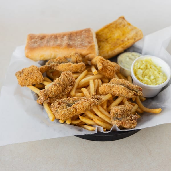 Fried catfish and french fries with two sides and bread, served in a basket.